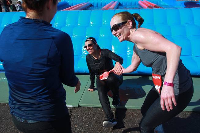 Amy Ashby is helped up by Kristi Trumblee, left, and Joanne Ashcraft after making it through the final obstacle of the Hit and Run 5k Saturday, March 1, 2014 at Sam Boyd Stadium. The Hit and Run 5k, a fun run with various obstacles to navigate, is being held or planned in two dozen cities across the country.